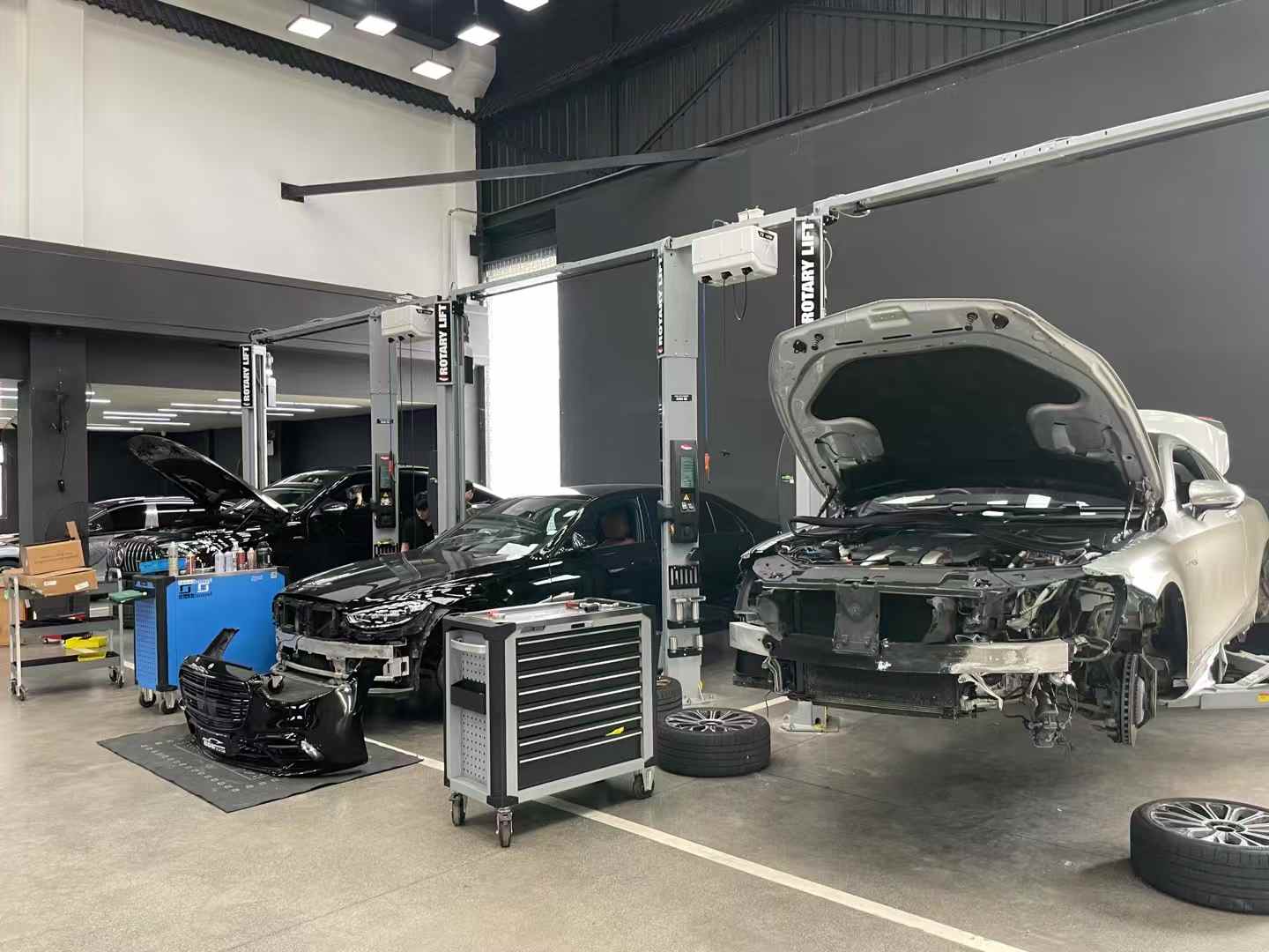 门店素材中的施工工位与车辆拆装场景;本图用于说明施工环境,不对应本文特定升级结果